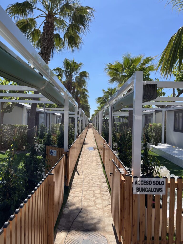 Toldo retráctil instalado en fachada, brindando sombra a la entrada y a una terraza exterior.