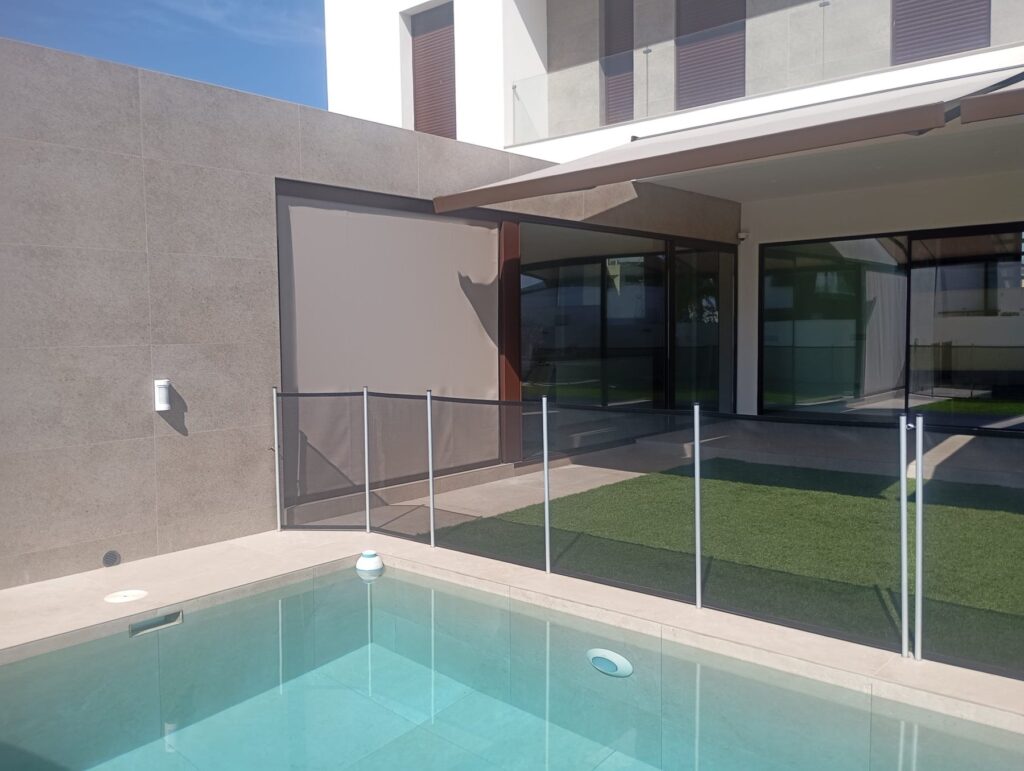 Toldo vertical Klais ZIP 110 en marrón cerrando el lateral del porche junto a la piscina