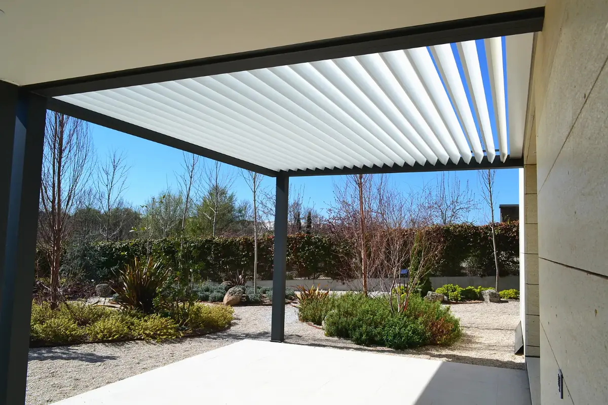 Pérgola bioclimática Majestic con lamas orientables en un jardín