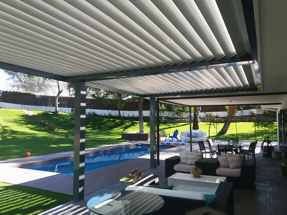 Pérgola bioclimática junto a la piscina de un jardín